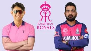 Rajasthan Royals coaches Sairaj Bahatule and Dishant Yagnik posing in front of the team logo in official team attire