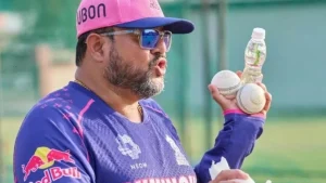 Siddhartha Lahiri, Rajasthan Royals coach, holding cricket balls and a water bottle during a training session.