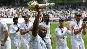 South Africa cricket captain Temba Bavuma holding the ICC Test mace while celebrating with teammates on the field