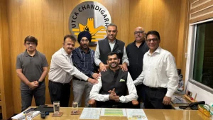 Group photo of UTCA Chandigarh officials including Saraansh Tandon, Daniel Banerjee, Hari Singh Khurana, Rahul Talwar, and Vinay Grover in front of UTCA logo