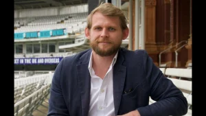 Angus Berry, CEO of the MCC Foundation, seated at Lord’s Cricket Ground in a formal suit.