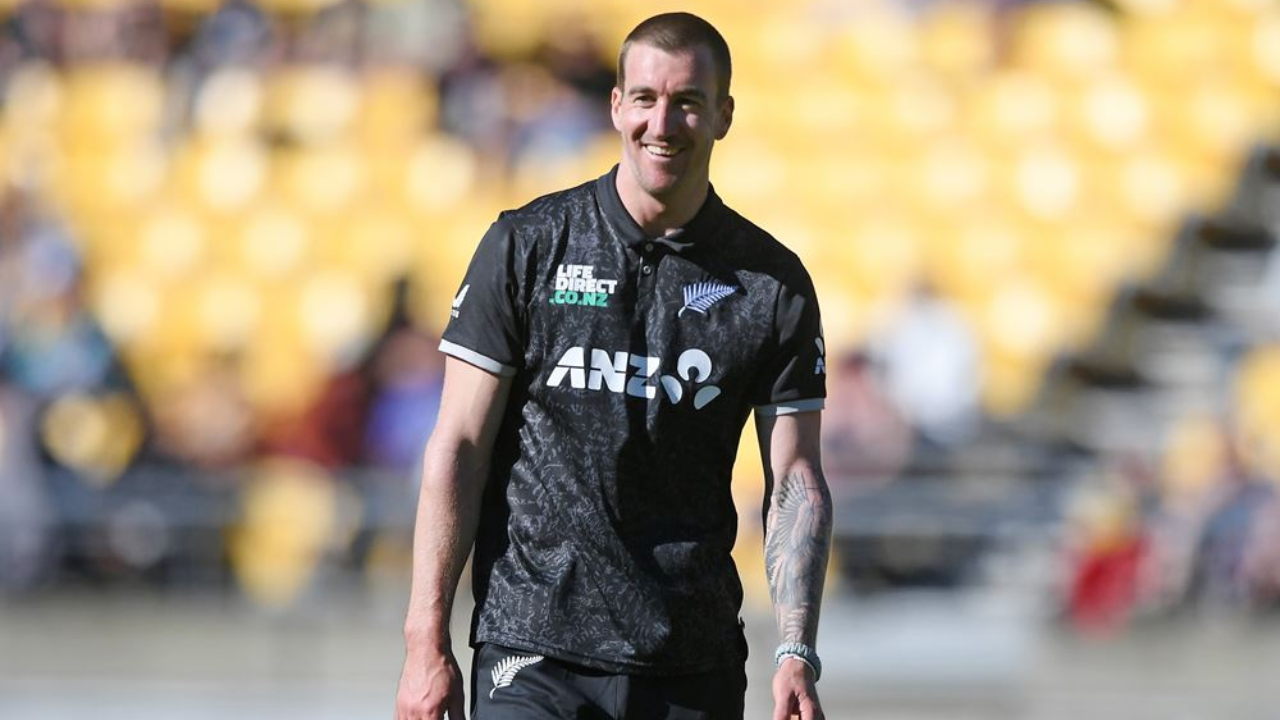 Blair Tickner of New Zealand smiles while on the field during a cricket match, wearing the national team’s black jersey.