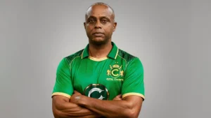 Courtney Walsh wearing a Royal Champs jersey in the T10 League, posing with arms crossed