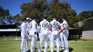 England men's cricket team in a huddle wearing white kits with Vitality branding during a match