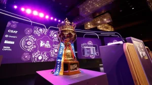 TATA Women's Premier League trophy displayed on a table with vibrant stage backdrop during WPL 2025 auction event