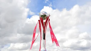 The Vitality Blast cricket trophy with red ribbons, displayed outdoors against a cloudy sky.