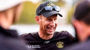 Western Australia cricket coach Adam Voges smiling during a team session, wearing a black cap and Murdoch University training kit.