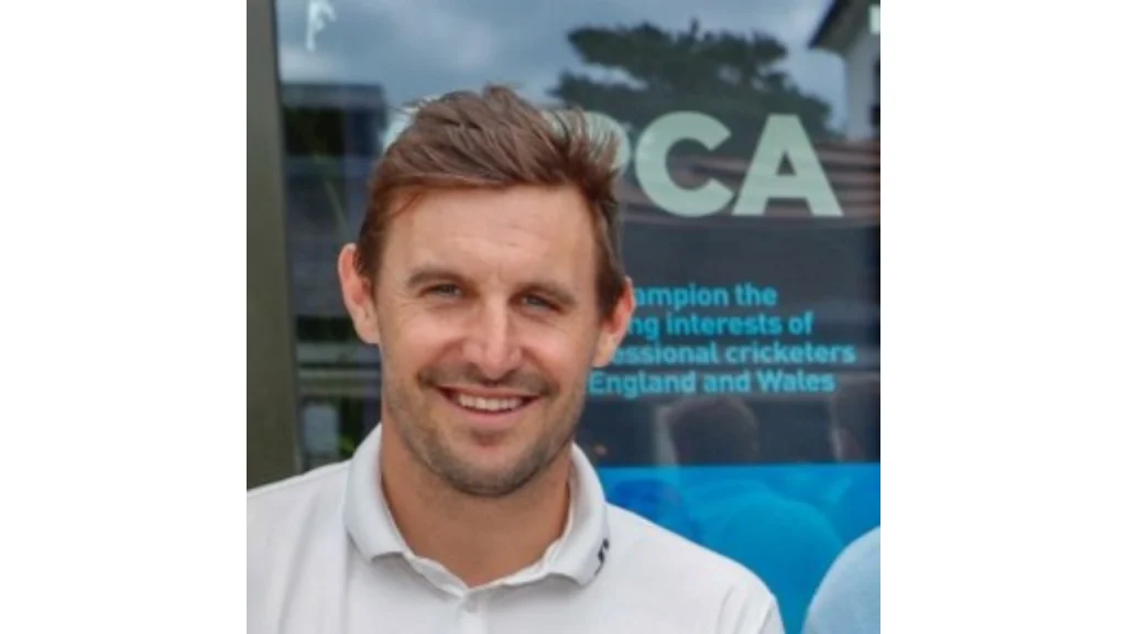 Daryl Mitchell, CEO of the Professional Cricketers' Association, smiling in front of PCA office signage