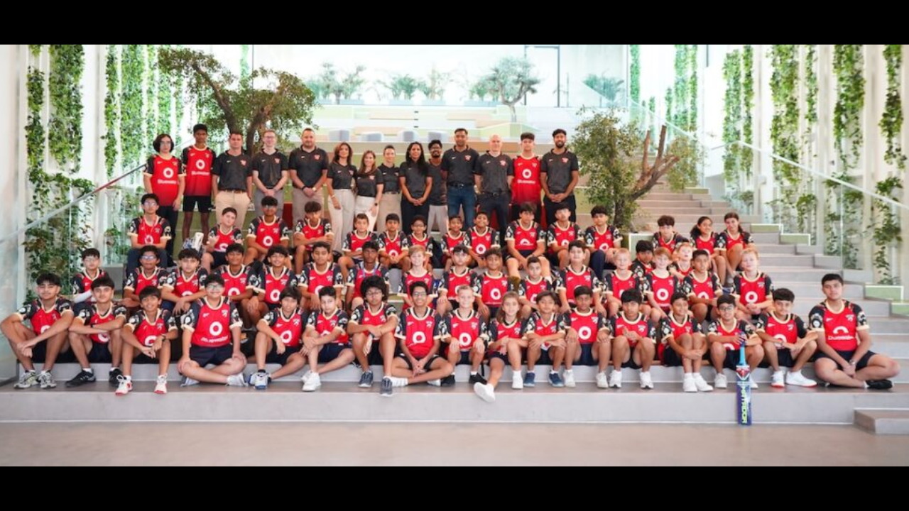Group photo of Desert Vipers cricket academy players and coaching staff posing together in team kits at an indoor facility in 2025.