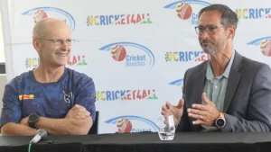 Gary Kirsten and Johan Muller speaking at a Cricket Namibia press conference, seated in front of a Cricket4All branded backdrop.