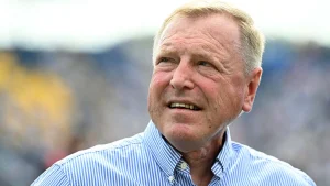 Hugh Morris looking away with a thoughtful expression at a stadium event