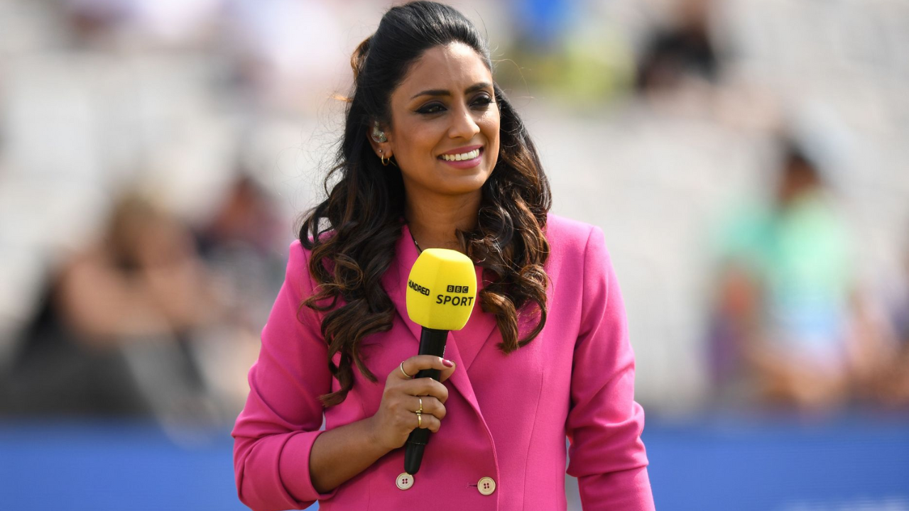 Isa Guha holding a BBC Sport microphone with The Hundred logo during a live cricket broadcast.