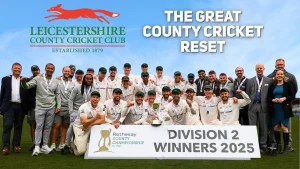 Leicestershire County Cricket Club team celebrating with the trophy after winning the Division 2 title in the 2025 County Championship, with club logo and banner in the background.