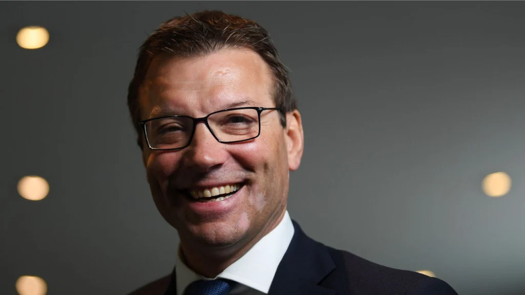 Rob Andrew, ECB Managing Director of the Professional Game, smiling in a formal suit and glasses