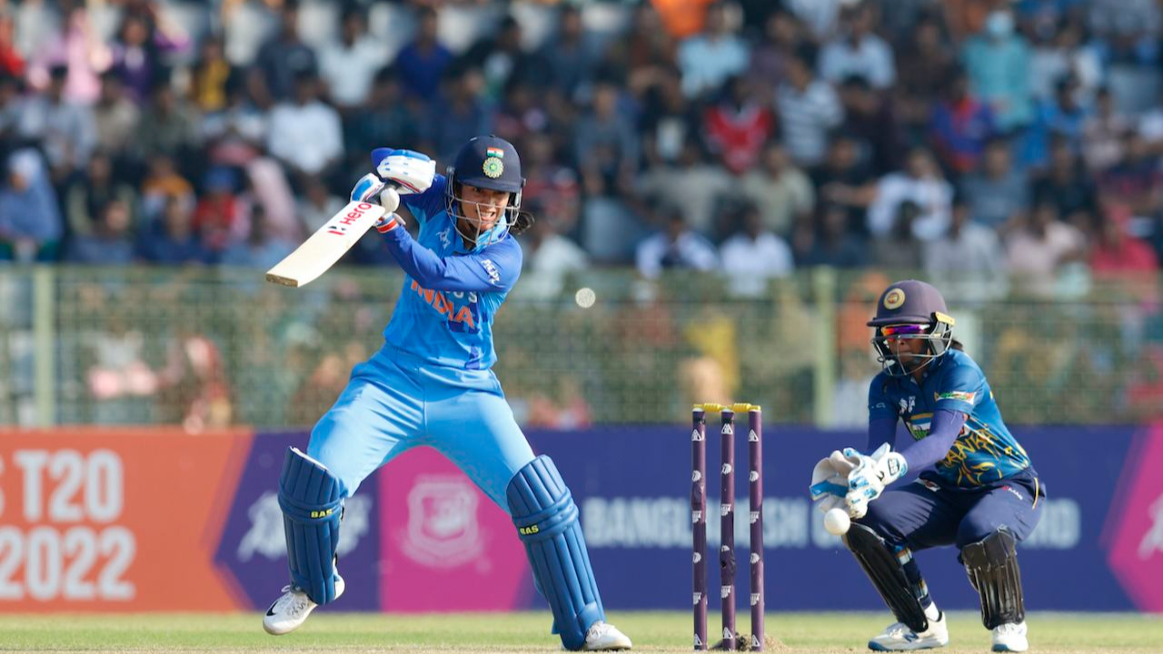 Indian cricketer Smriti Mandhana plays a shot during a women's T20 match against Sri Lanka at the 2022 Women's Asia Cup, with the Sri Lankan wicketkeeper ready behind the stumps.