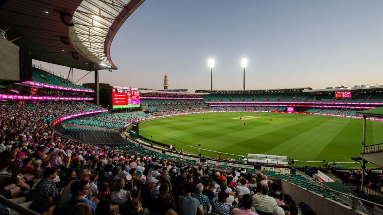 Evening cricket match at a packed Sydney Cricket Ground with spectators filling the stands under floodlights