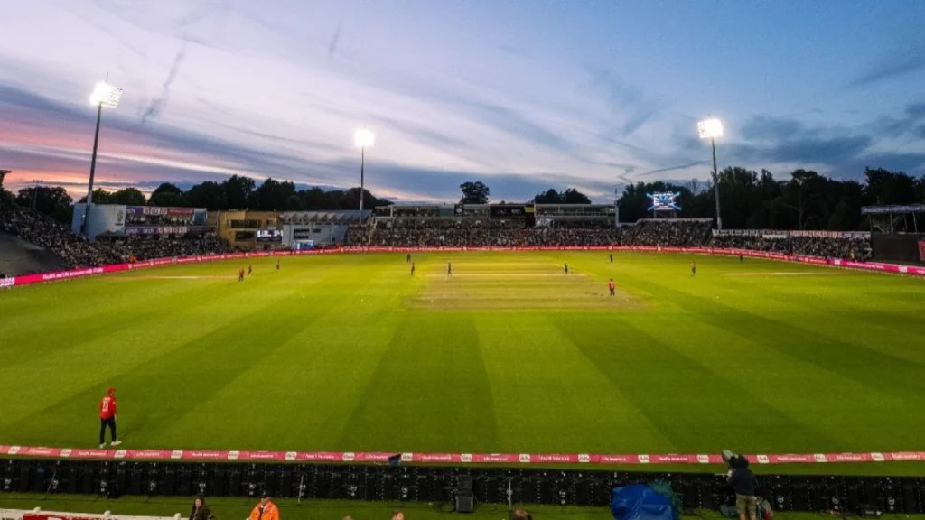 Evening view of The Hundred cricket match at Sophia Gardens in Cardiff, with players on the field and a full crowd under floodlights