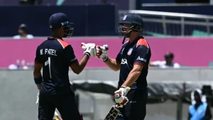 USA cricketers celebrate a batting partnership as Monank Patel and teammate fist-bump during an international match.