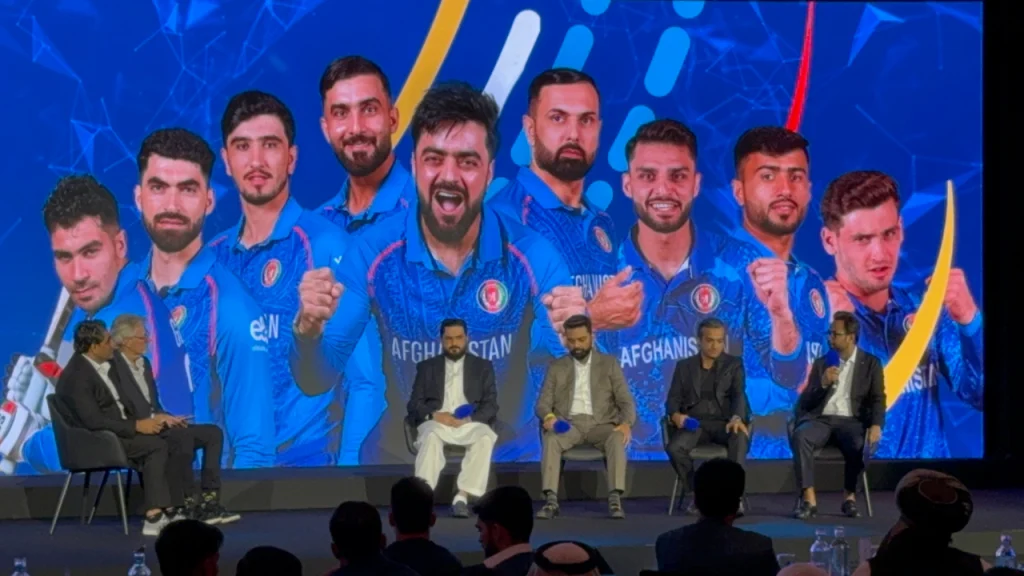 Vivek Chandra of ITW speaks during an executive panel at the Afghanistan Premier League 2025 launch, alongside Naseeb Khan (ACB), Mubashshir Usmani (Emirates Cricket Board), and Rao Usman Khan (Trans Group), with Afghan national players displayed on a large backdrop.