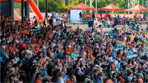 Large crowd of Perth Scorchers fans in orange cheering at a Big Bash League match at Optus Stadium