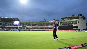 Cricketer Charlie Wakim fielding near the boundary during a Big Bash League (BBL) match at Blundstone Arena under evening lights with spectators in the stands.