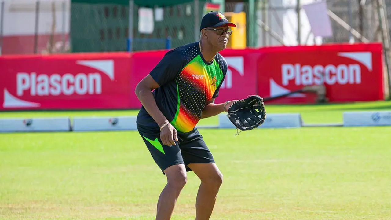 Courtney Walsh wearing a Zimbabwe cricket practice jersey during a training session on the field.