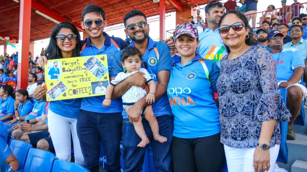 Crickbuster clients and families showing support for Team India during a cricket match in Florida, holding creative signs and wearing India jerseys