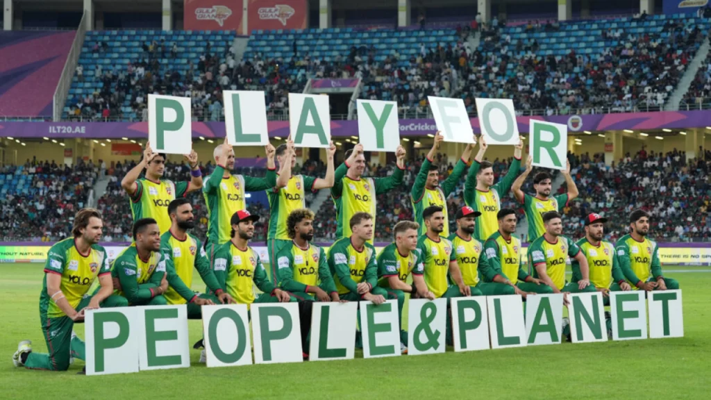Desert Vipers players display 'Play for People & Planet' signs on field during ILT20 2026 sustainability campaign match