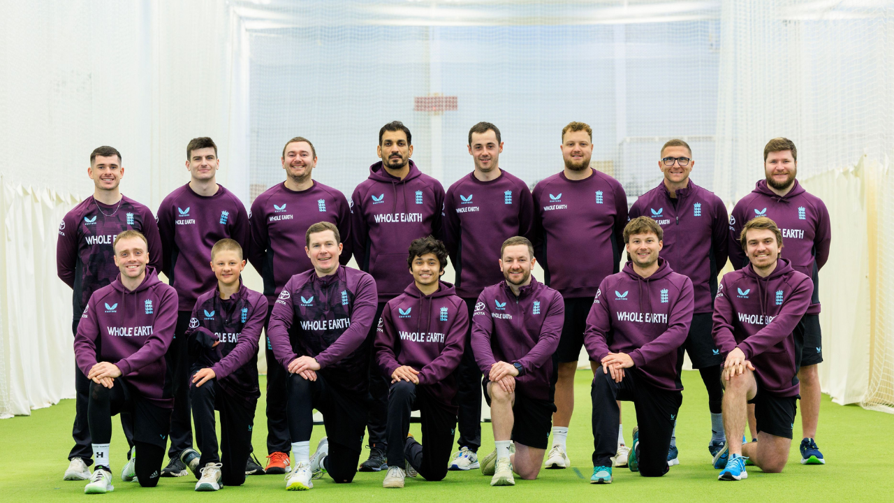 England Mixed Disability Cricket team posing together in training gear during an indoor session, wearing maroon Whole Earth hoodies