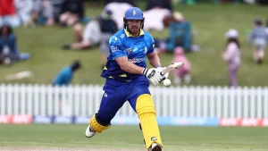 Glenn Phillips in action during a Super Smash cricket match, wearing blue and yellow kit while batting