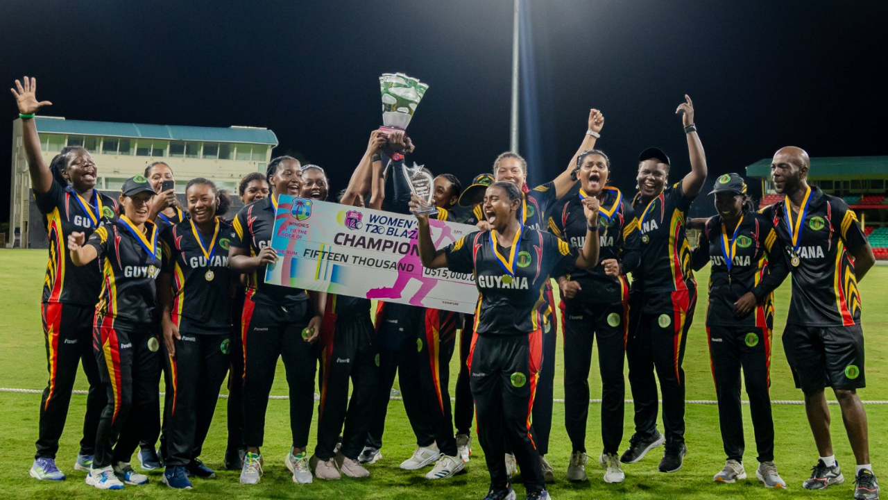 Guyana women's cricket team celebrating their championship win at the CG United Women’s Super50 Cup 2024 with trophy, medals, and prize cheque on the field