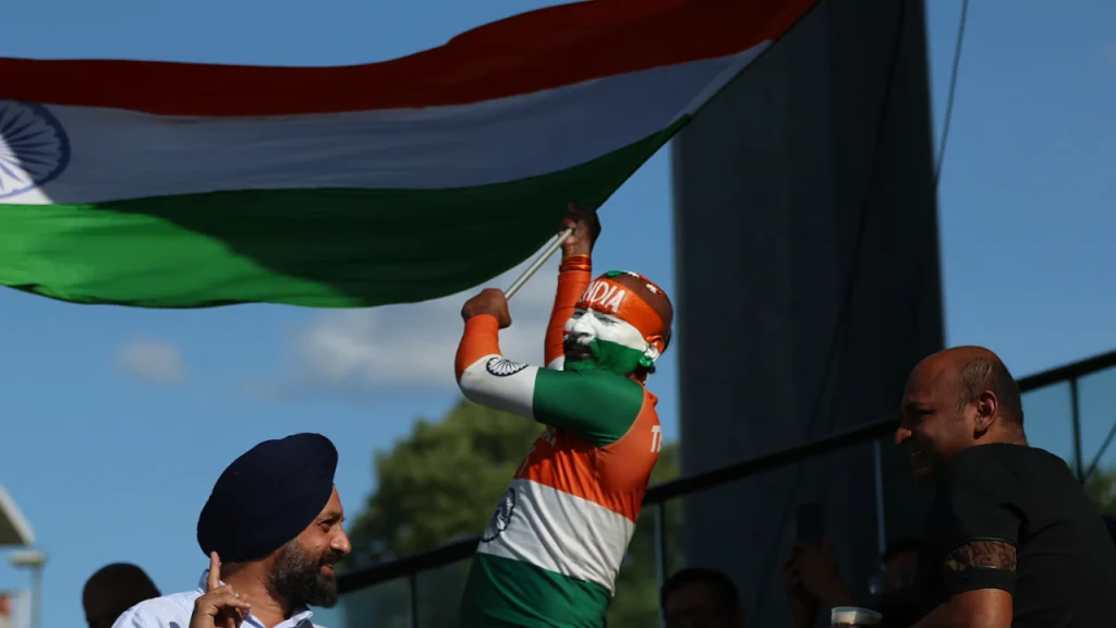 Indian cricket fan waving the national flag at Edgbaston Stadium, showing vibrant support during a match.