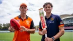 Mitch Marsh holding a Sherrin football alongside an AFL player with a cricket bat at Adelaide Oval, promoting cross-sport collaboration.