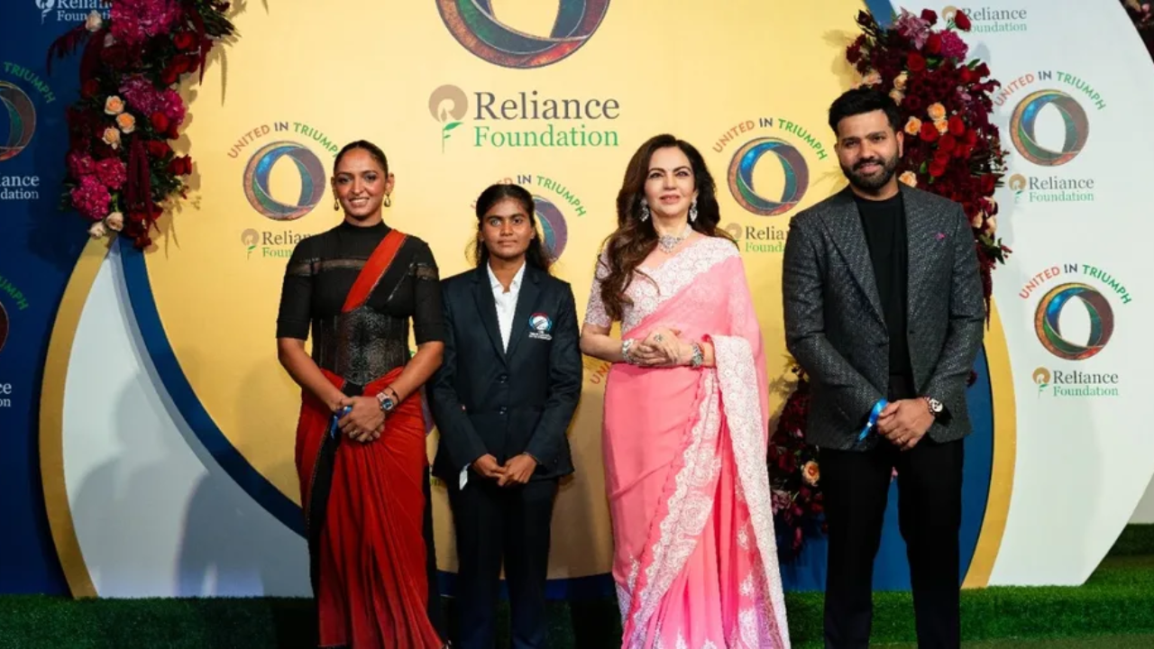 Nita Ambani, Rohit Sharma, Harmanpreet Kaur, and Deepika TC at a Reliance Foundation event with United in Triumph branding in the background