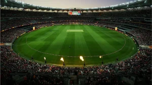 Packed crowd at Optus Stadium during an evening cricket match under stadium lights