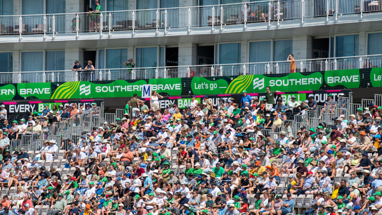 Crowd of Southern Brave fans wearing green and cheering in a packed stadium during The Hundred cricket tournament in 2026.