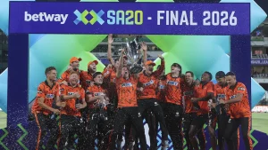 Sunrisers Eastern Cape players celebrate winning the SA20 Season 4 Final 2026, lifting the trophy and spraying champagne on stage.