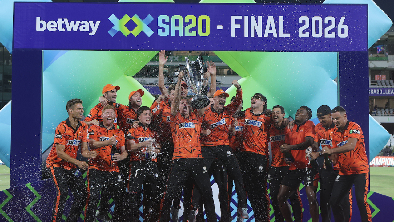 Sunrisers Eastern Cape players celebrate winning the SA20 Season 4 Final 2026, lifting the trophy and spraying champagne on stage.