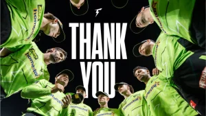 Sydney Thunder players wearing green jerseys in a team huddle with "Thank You" text in the center, captured from a low angle after a match.