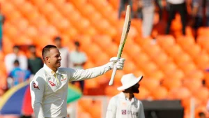 Usman Khawaja acknowledges the crowd with his bat after scoring a century in a test match against India