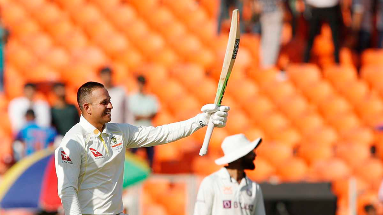 Usman Khawaja acknowledges the crowd with his bat after scoring a century in a test match against India