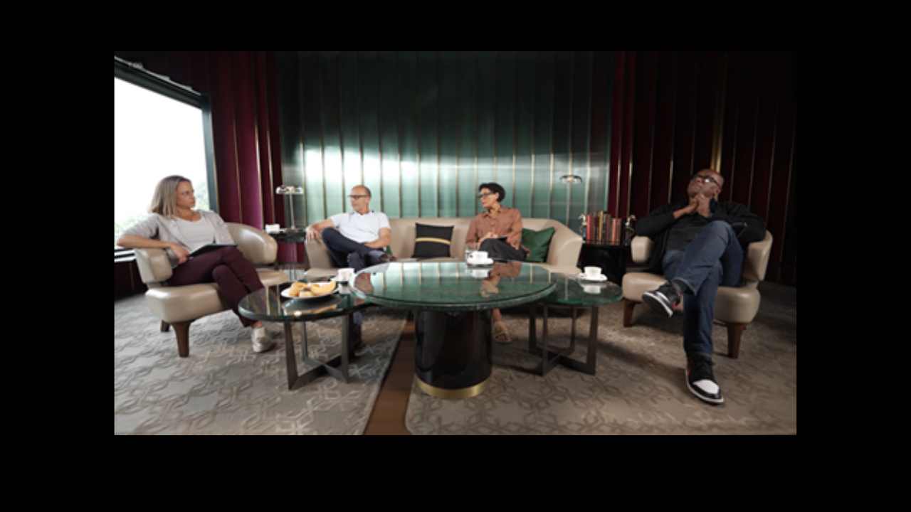 Mel Jones, Nasser Hussain, and Ian Bishop in a cricket panel discussion seated in a lounge with coffee and snacks