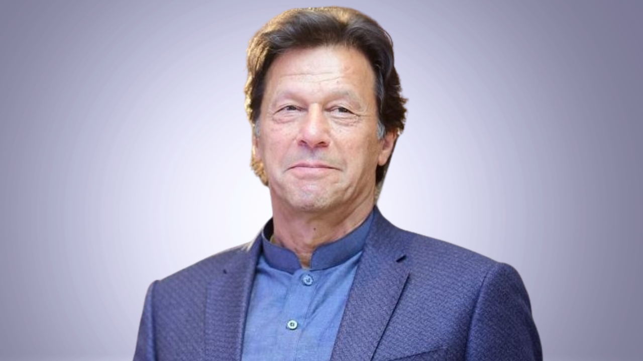 Portrait of Imran Khan, former Prime Minister of Pakistan, wearing a blue sherwani-style outfit and blazer against a neutral background.