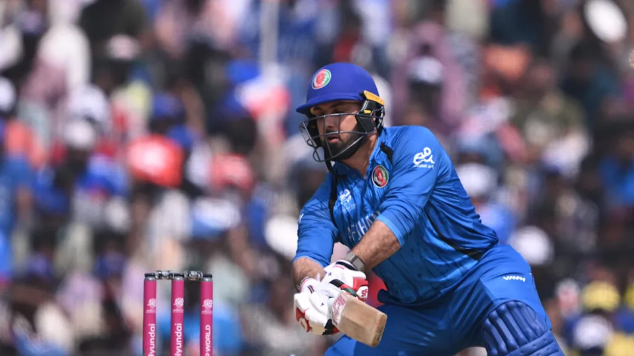 Mohammad Nabi playing an attacking shot in Afghanistan jersey during an international cricket match.