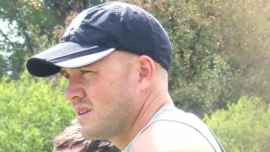 Peter Fulton in a training session setting, wearing a cap during a cricket coaching role.