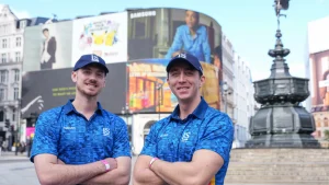 Two cricket players in London Spirit jerseys standing at Piccadilly Circus as Cricket District announces an exclusive content deal with the team