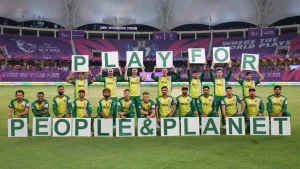 Desert Vipers team posing with “Play for People & Planet” signs at Dubai International Stadium during ILT20 match