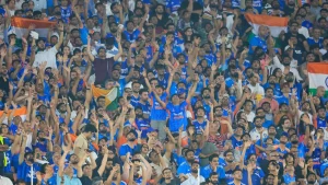 Indian cricket fans cheering in a packed stadium waving tricolor flags and celebrating during a live match