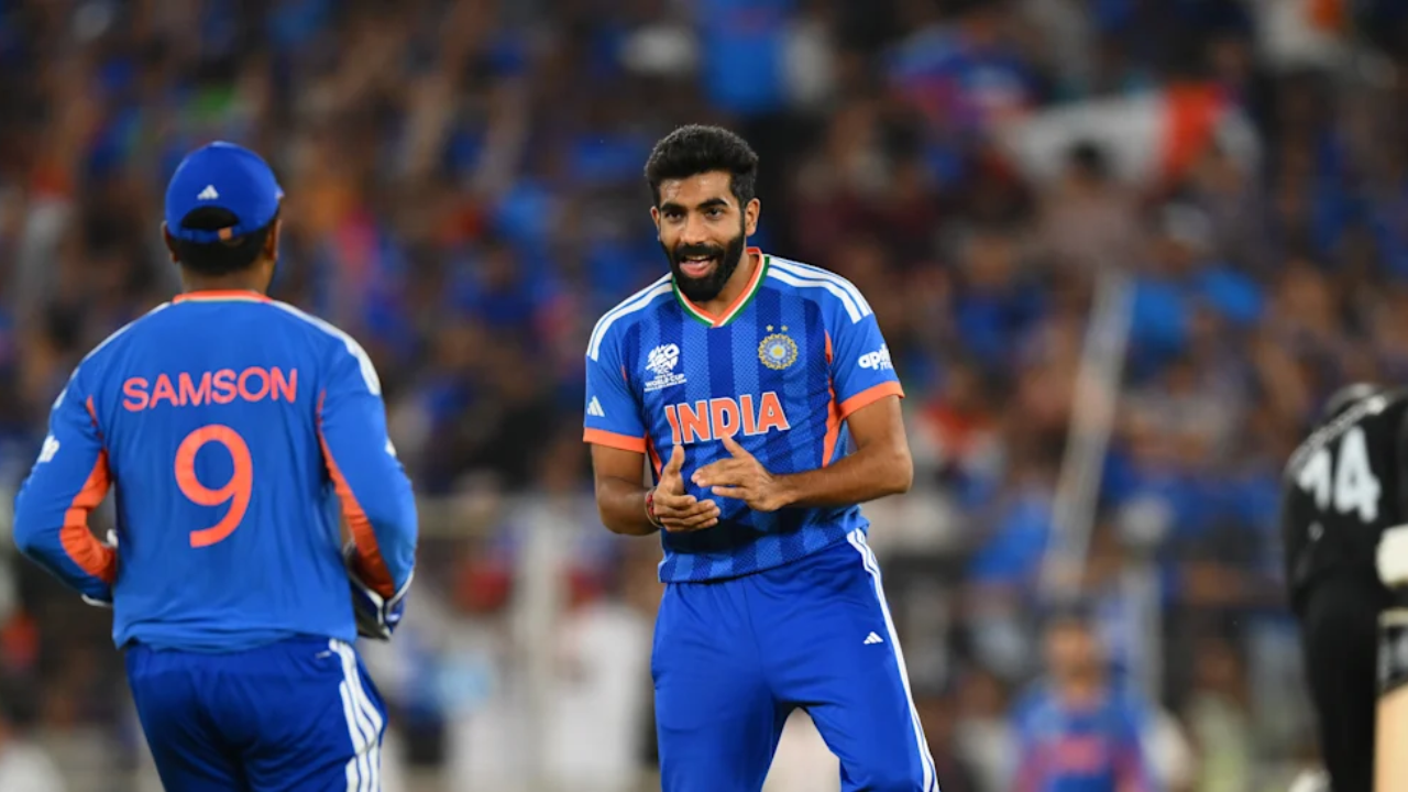 Sanju Samson and Jasprit Bumrah in India cricket team jerseys during a T20 international match, celebrating a wicket on the field.