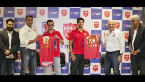 Shashank Singh and Yuzvendra Chahal unveil Punjab Kings jerseys during IPL launch event with team officials and sponsor backdrop